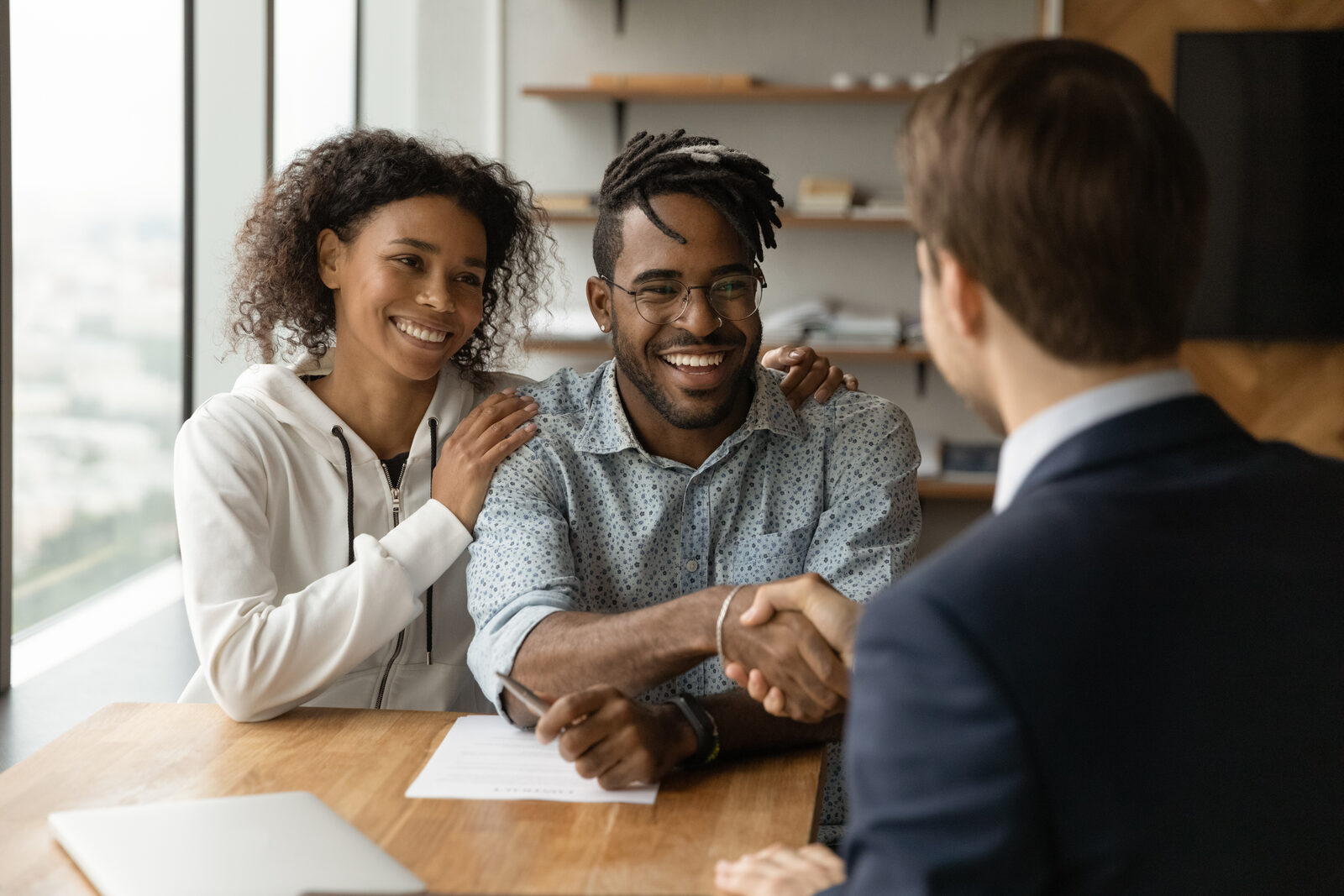 Insurance agent shaking hands with a smiling couple